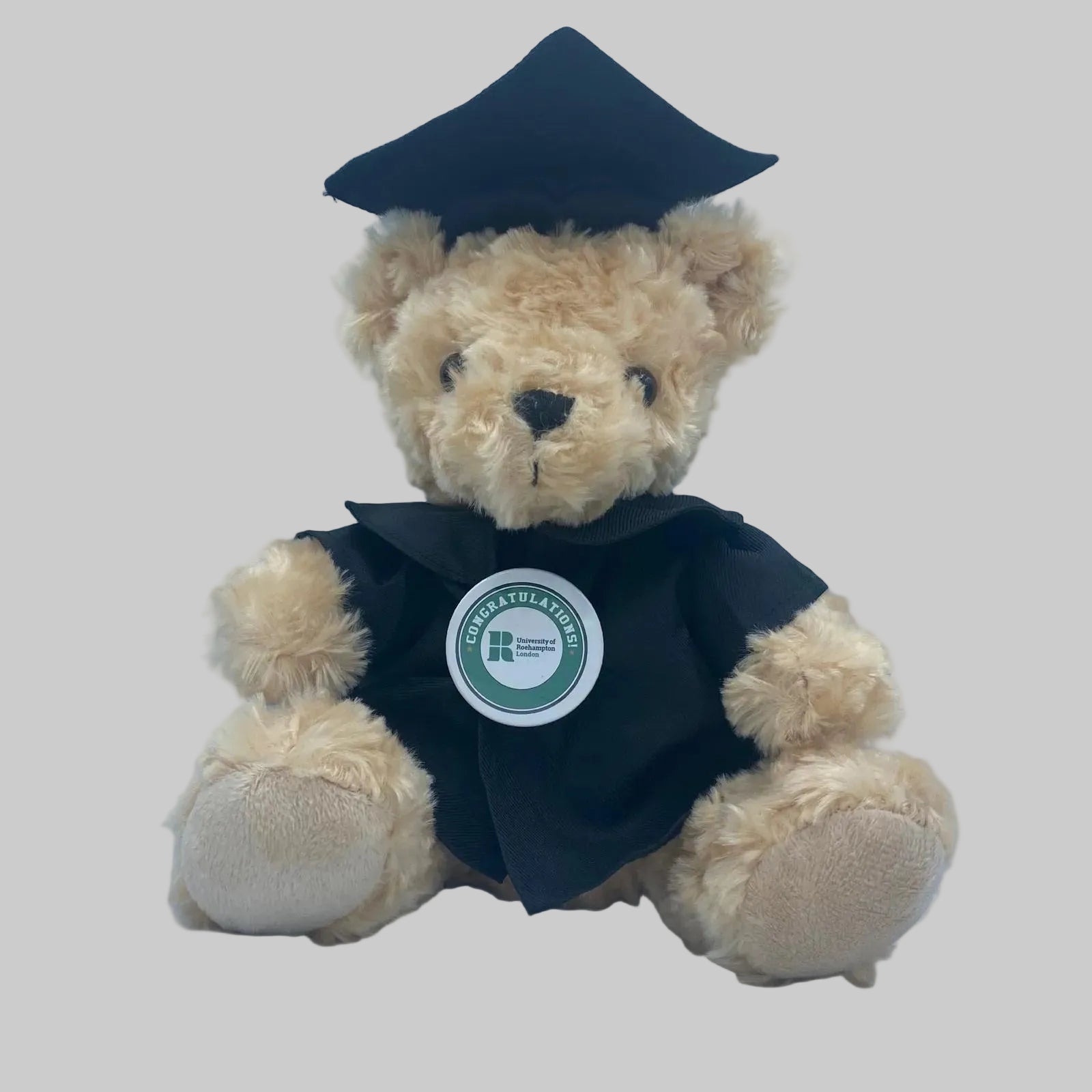 Graduation-themed teddy bear with a cap and gown on a light blue background