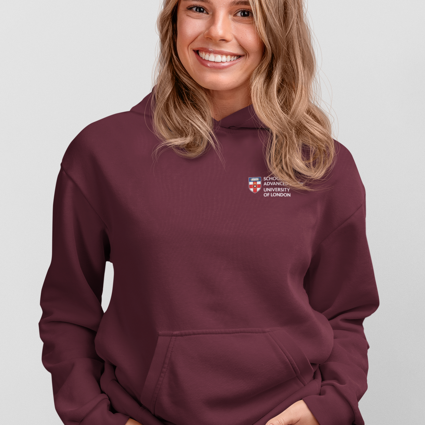 Woman wearing a maroon hoodie with a logo on a light gray background