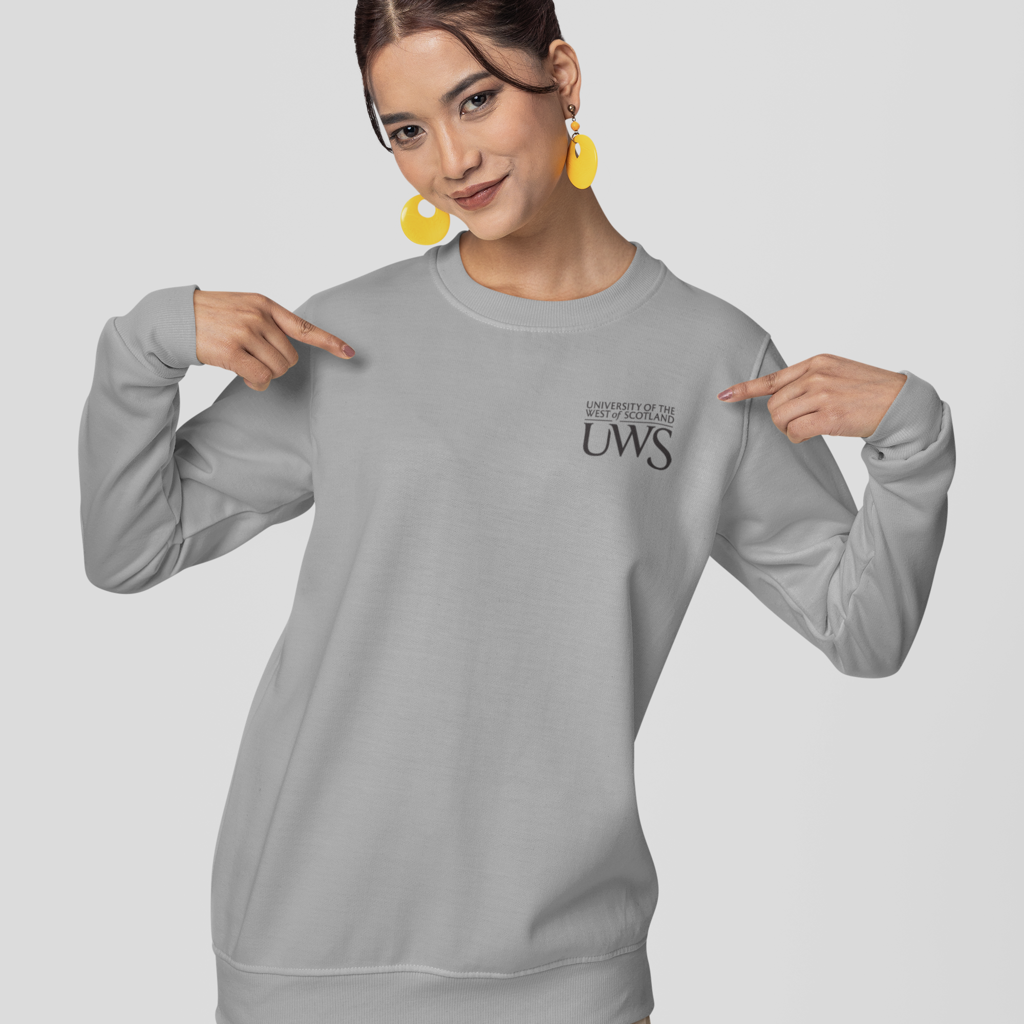 Woman wearing a gray sweatshirt with a logo and text on a light gray background