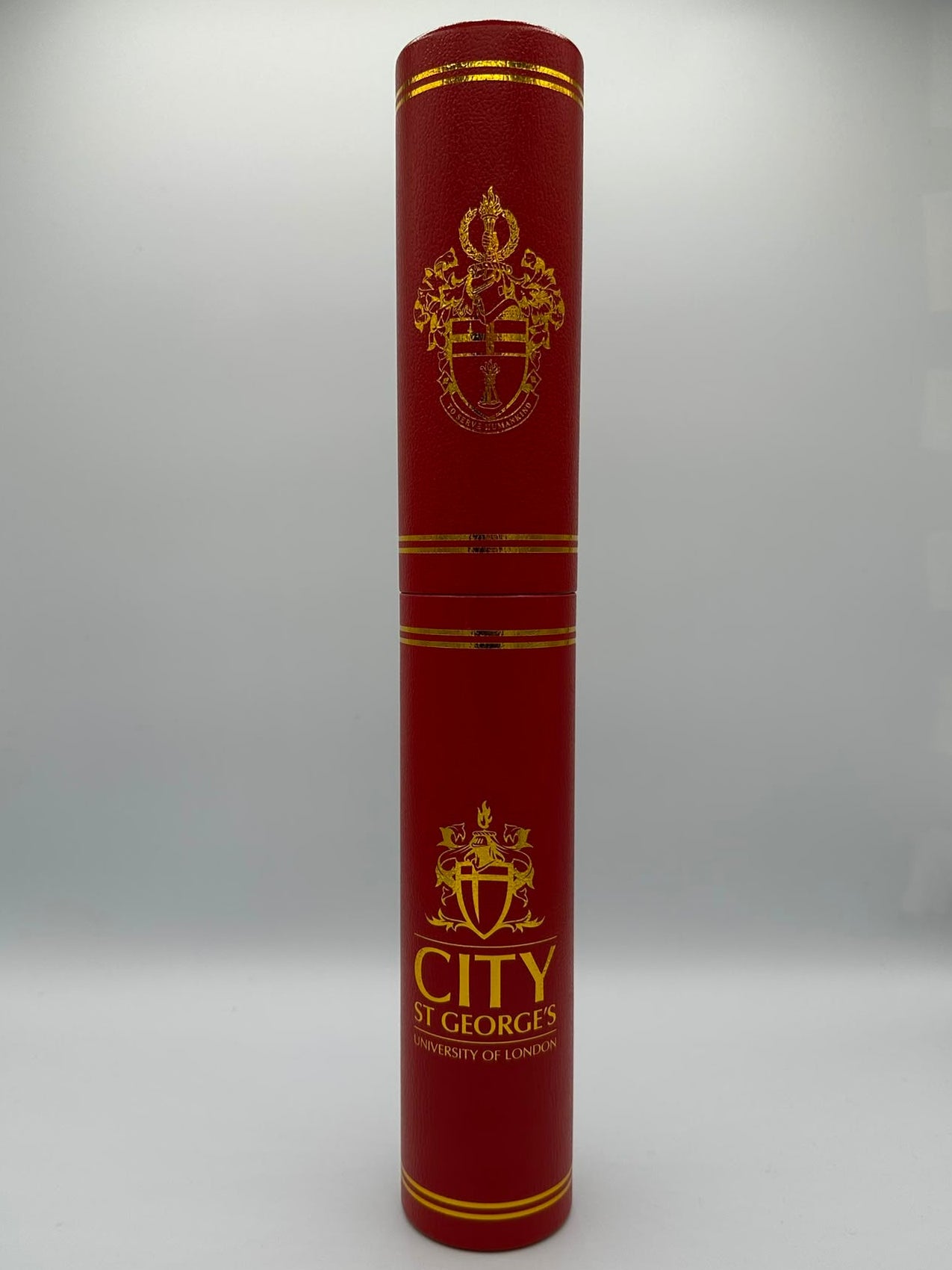 Red cylindrical product with gold accents and 'City of St. George's' branding on a white background