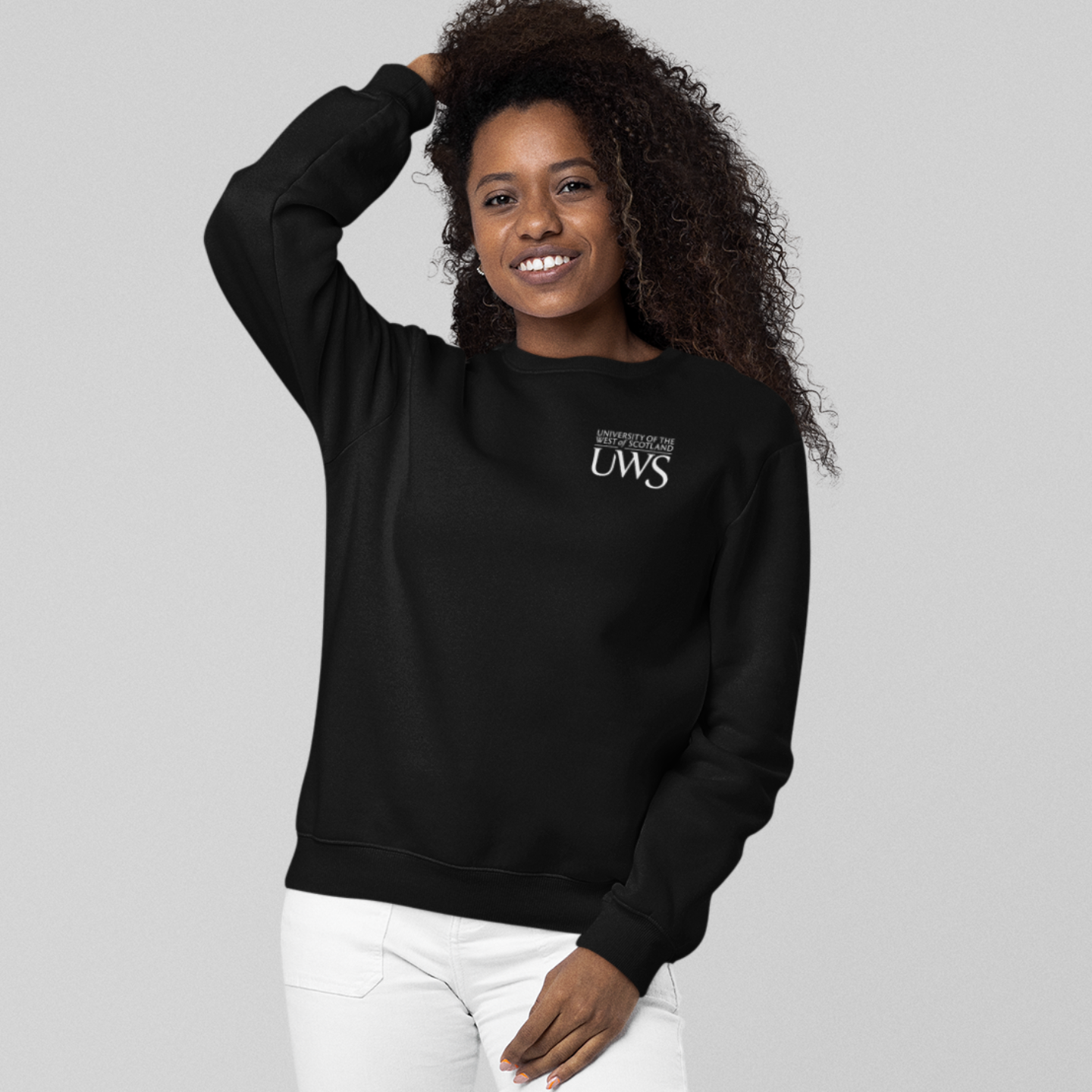 Person wearing a black sweatshirt with a logo on a gray background