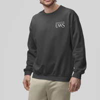 Man wearing a dark gray sweatshirt and beige pants on a light gray background